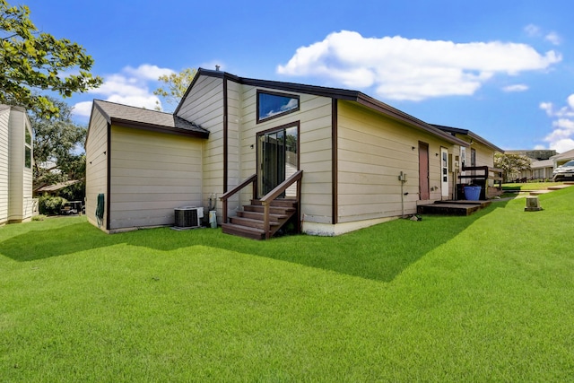 rear view of house featuring a yard and central air condition unit