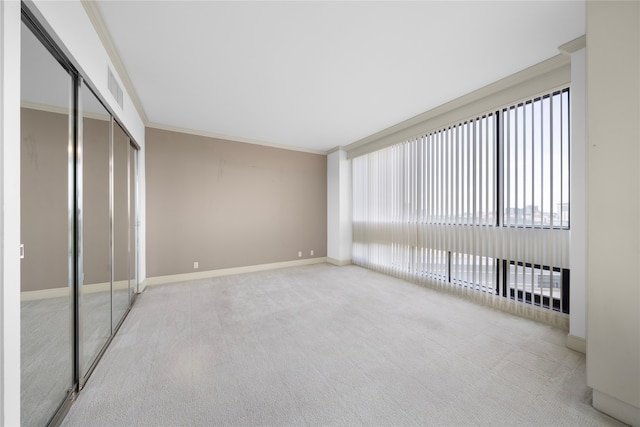 unfurnished bedroom featuring a closet, light colored carpet, and ornamental molding