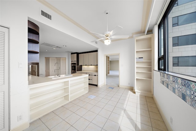 kitchen featuring double oven, ceiling fan, sink, and light tile patterned floors