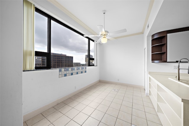 unfurnished dining area with ceiling fan, ornamental molding, and light tile patterned floors