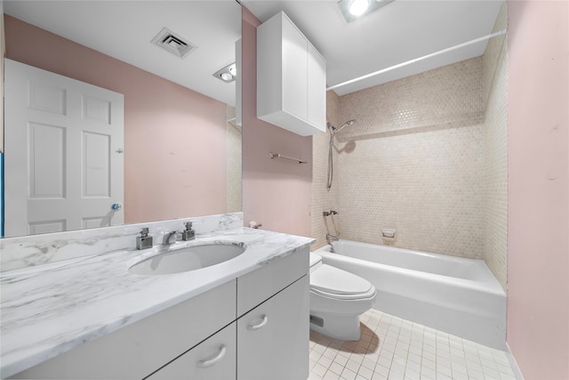 full bathroom featuring tile patterned floors, vanity, tiled shower / bath combo, and toilet