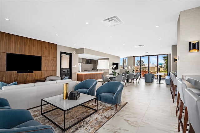 living room featuring floor to ceiling windows and wooden walls