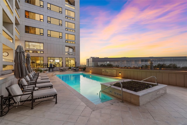 pool at dusk with a patio