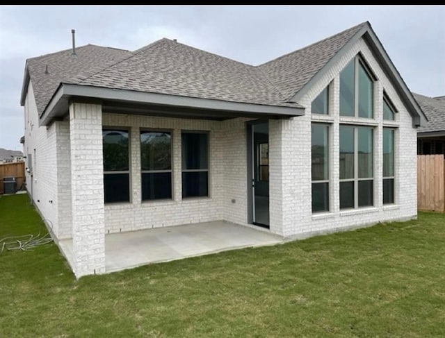 back of house featuring central AC unit, a yard, and a patio