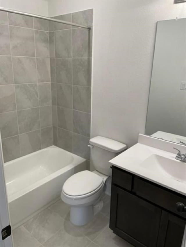 full bathroom featuring vanity, tiled shower / bath combo, and toilet