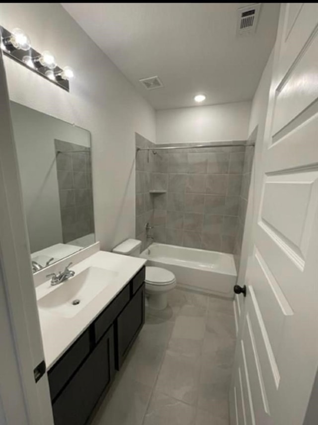 full bathroom featuring toilet, vanity, and tiled shower / bath