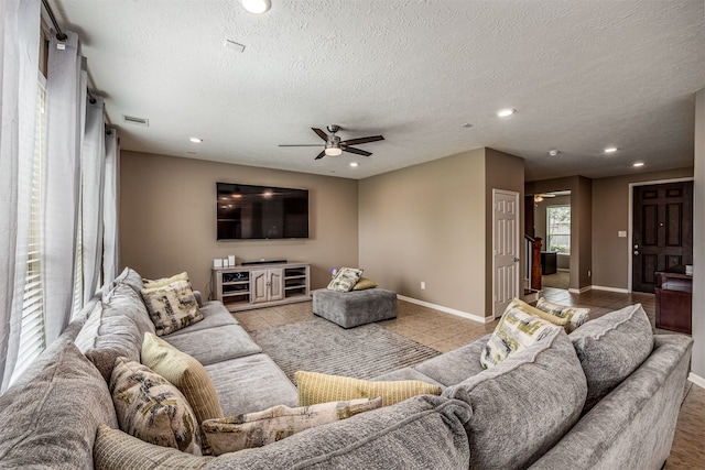 tiled living room with a textured ceiling and ceiling fan