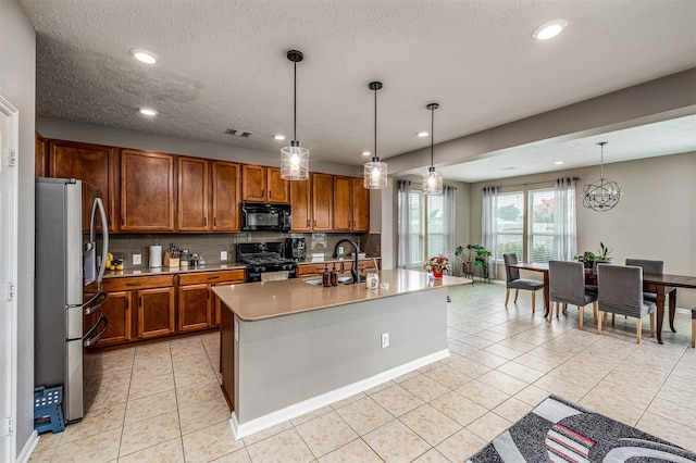 kitchen with black appliances, hanging light fixtures, sink, and light tile floors