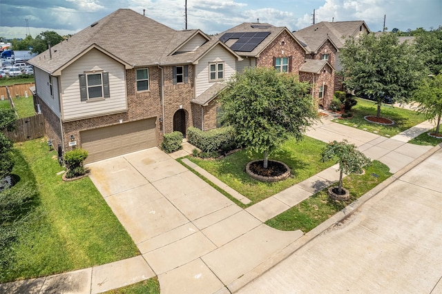 view of front of home with a garage, a front lawn, and solar panels