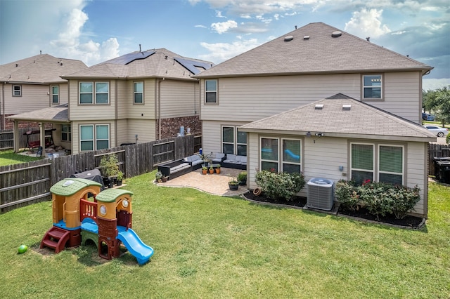 back of house featuring a playground, a lawn, a patio area, and central air condition unit