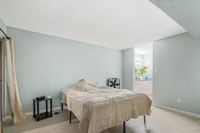 bedroom featuring a textured ceiling and ensuite bath