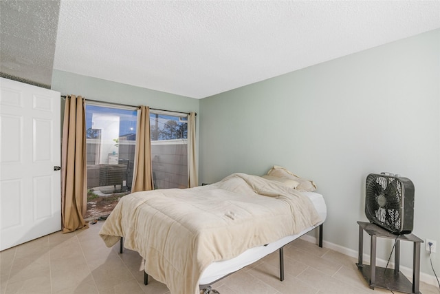 tiled bedroom featuring a textured ceiling