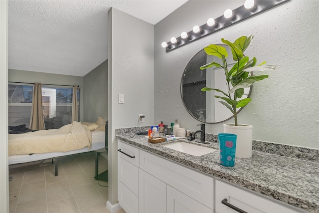 bathroom featuring tile patterned flooring, vanity, and a textured ceiling