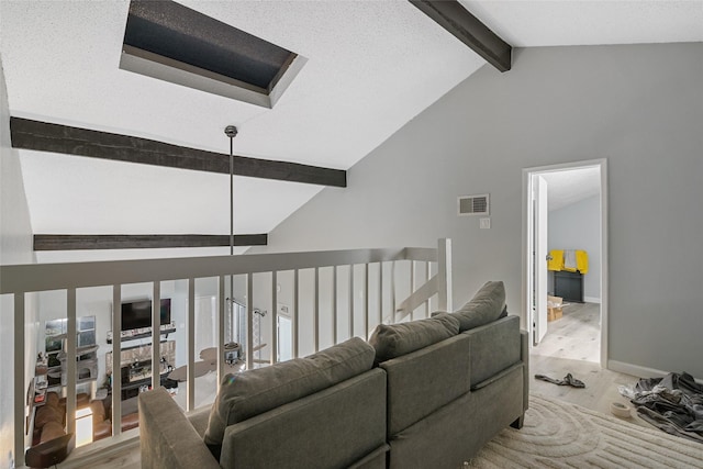 living room with a textured ceiling and lofted ceiling with beams