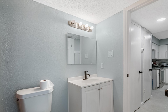 bathroom featuring tasteful backsplash, vanity, a textured ceiling, and toilet