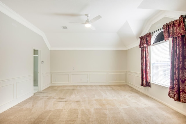 empty room with light carpet, lofted ceiling, and crown molding