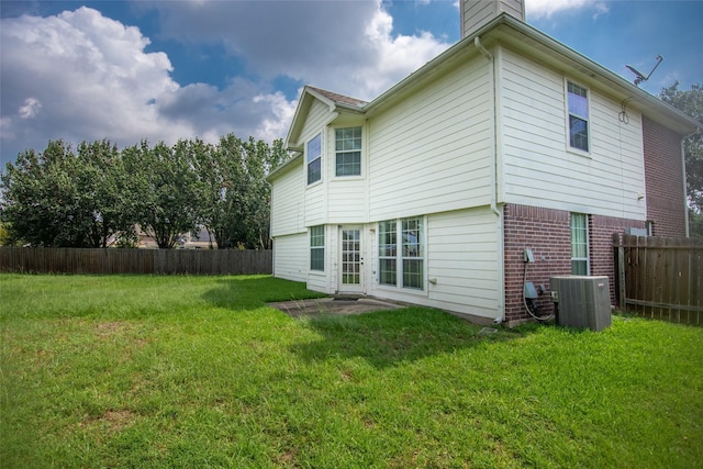 rear view of property with a lawn and cooling unit