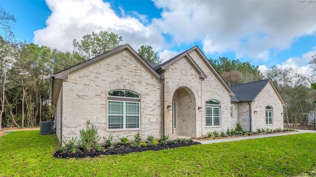 french country style house with a front lawn and central AC unit