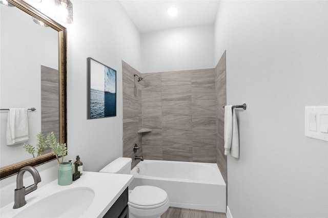 full bathroom featuring tiled shower / bath combo, toilet, and vanity