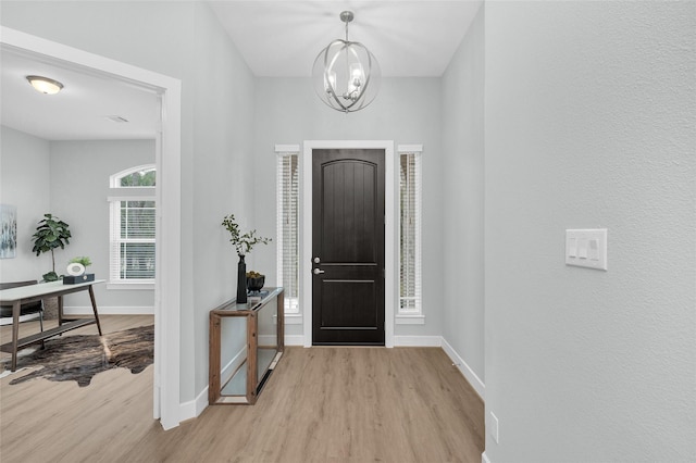 entrance foyer featuring light hardwood / wood-style floors and a chandelier