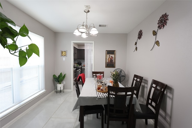 tiled dining room featuring an inviting chandelier