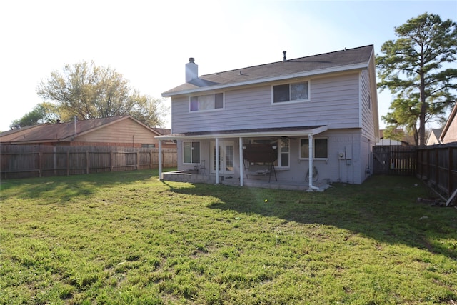 rear view of property featuring a patio area and a lawn