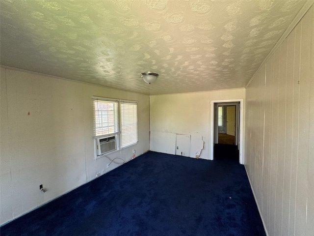 carpeted spare room featuring cooling unit and a textured ceiling