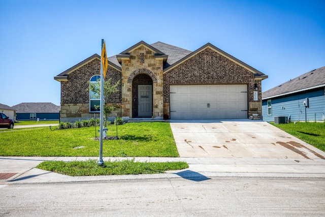 front of property featuring cooling unit, a garage, and a front yard