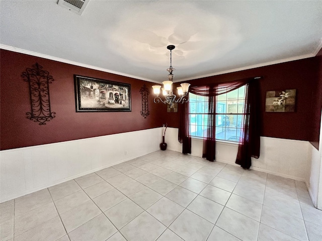 spare room with ornamental molding, light tile patterned flooring, visible vents, and an inviting chandelier