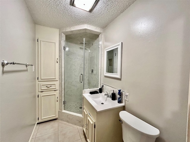 full bath featuring a marble finish shower, toilet, vanity, a textured ceiling, and tile patterned floors