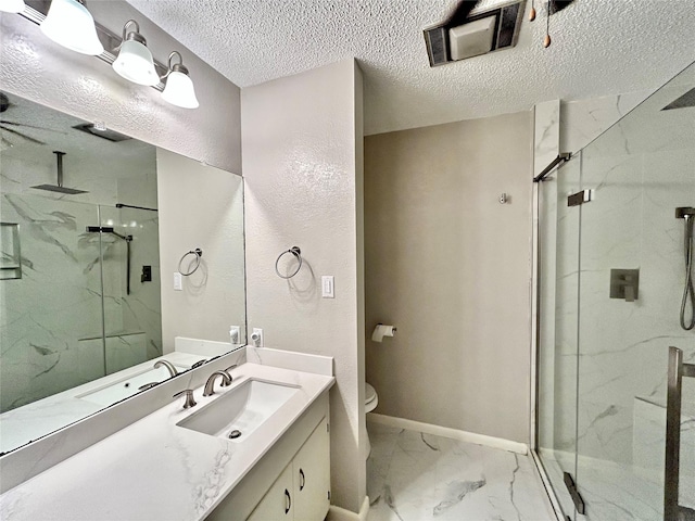 full bath with marble finish floor, a marble finish shower, toilet, vanity, and a textured ceiling