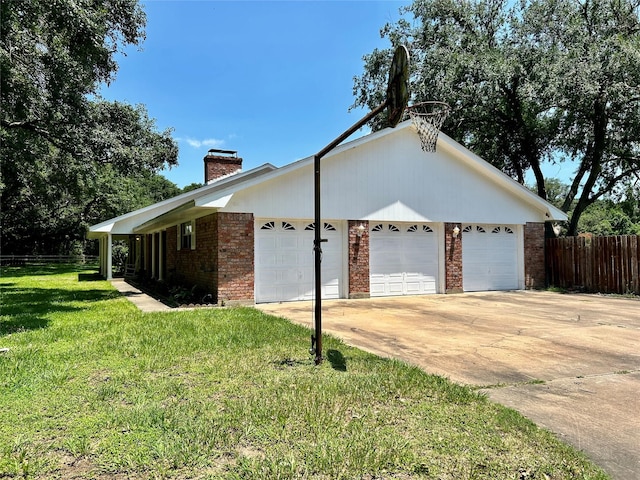 view of property exterior featuring brick siding, a chimney, a lawn, an attached garage, and driveway