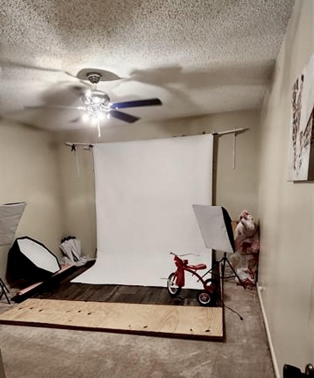 interior space featuring a ceiling fan, a textured ceiling, and wood finished floors