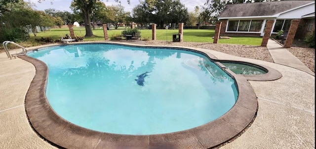 view of swimming pool with a pool with connected hot tub and a lawn