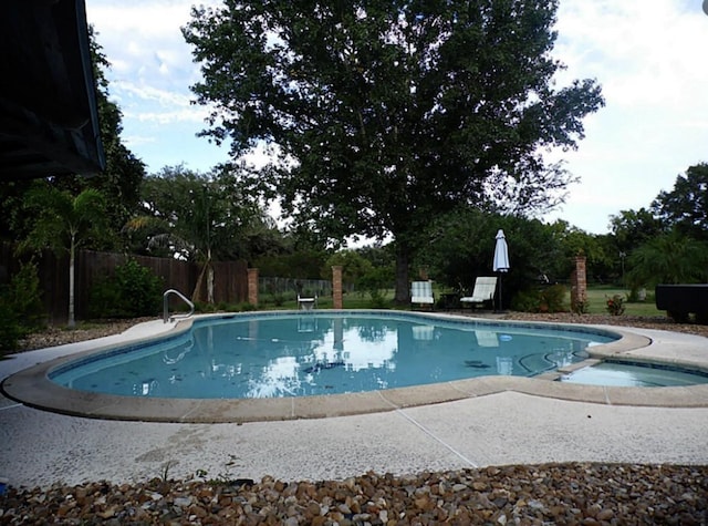 view of pool featuring an in ground hot tub, fence, and a fenced in pool