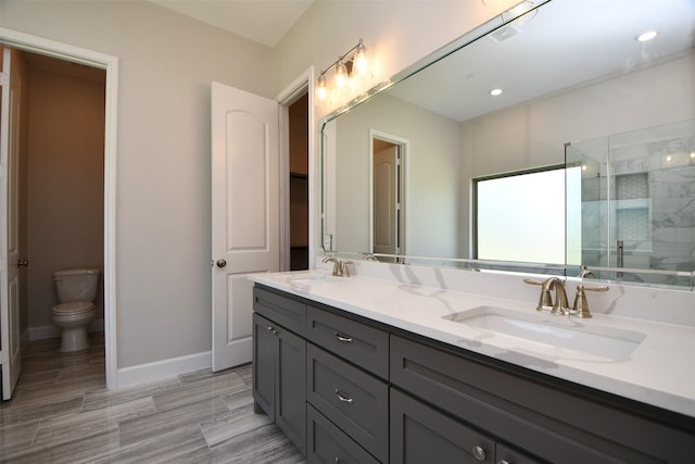 bathroom featuring vanity, toilet, and walk in shower