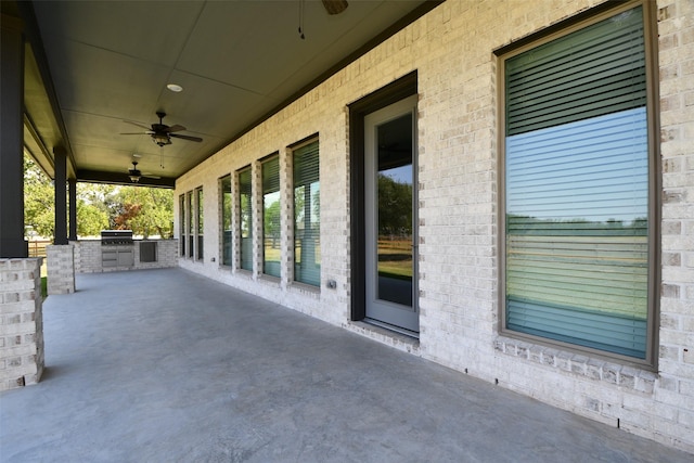 view of patio featuring ceiling fan, area for grilling, and a grill