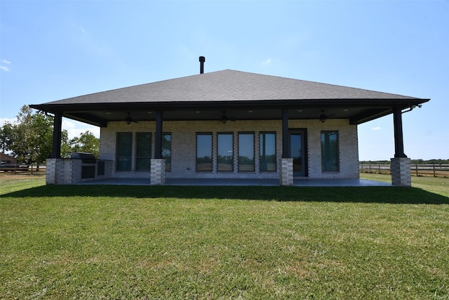 back of house featuring ceiling fan, a yard, and exterior kitchen