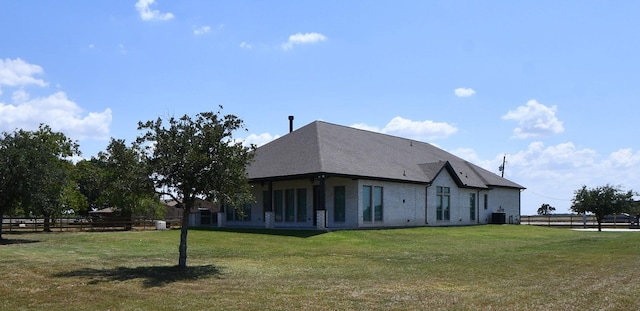 back of house featuring a yard and central AC