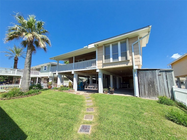 back of house with a lawn and a balcony