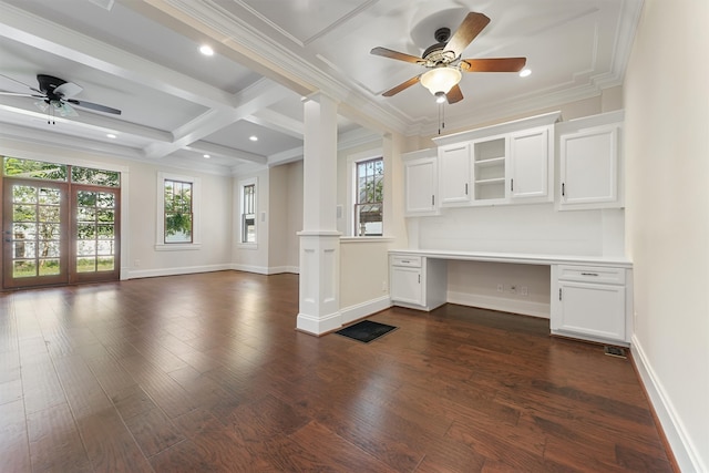 unfurnished office with coffered ceiling, crown molding, built in desk, ceiling fan, and beam ceiling