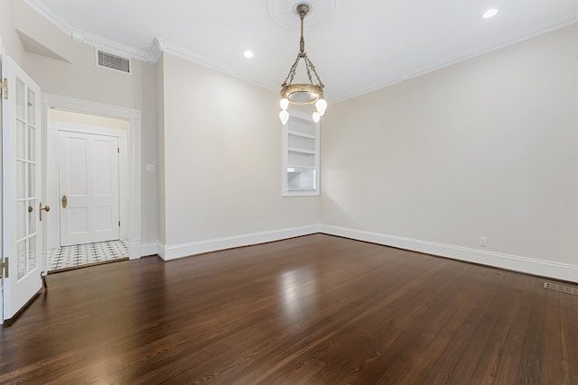 spare room with crown molding, dark hardwood / wood-style flooring, and built in shelves