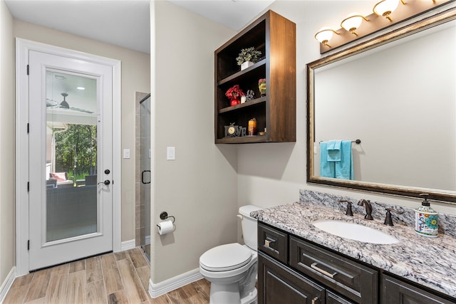 bathroom featuring hardwood / wood-style flooring, vanity, an enclosed shower, and toilet