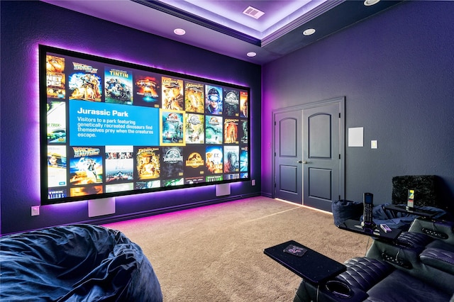 carpeted home theater room with a tray ceiling