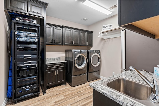 washroom with separate washer and dryer, sink, and cabinets