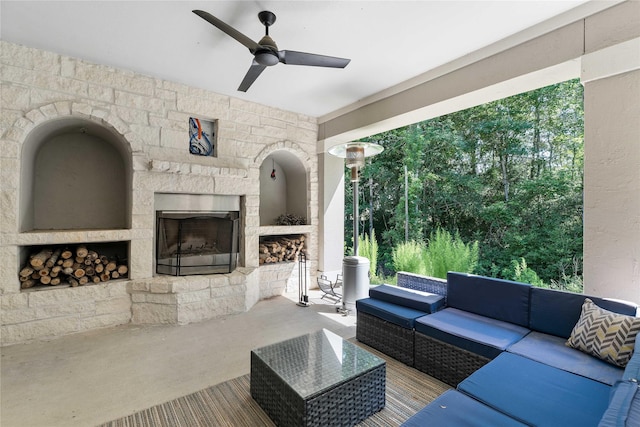 exterior space with ceiling fan, concrete floors, and an outdoor stone fireplace