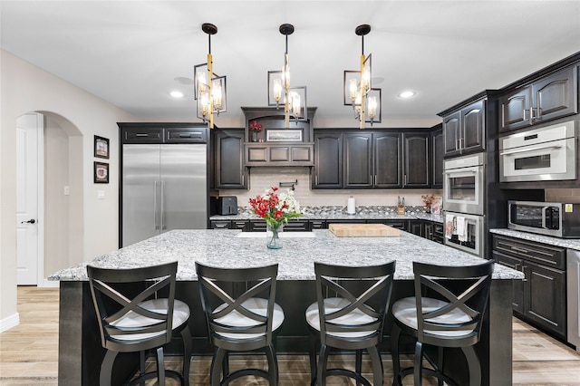 kitchen with tasteful backsplash, appliances with stainless steel finishes, and a spacious island