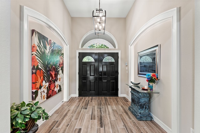 entryway with an inviting chandelier and a towering ceiling