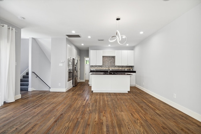 kitchen with decorative light fixtures, white cabinetry, tasteful backsplash, and dark hardwood / wood-style floors