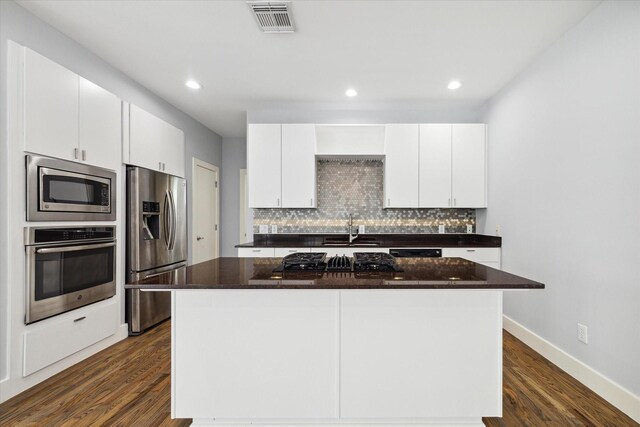 kitchen featuring a center island, dark hardwood / wood-style flooring, white cabinetry, and appliances with stainless steel finishes